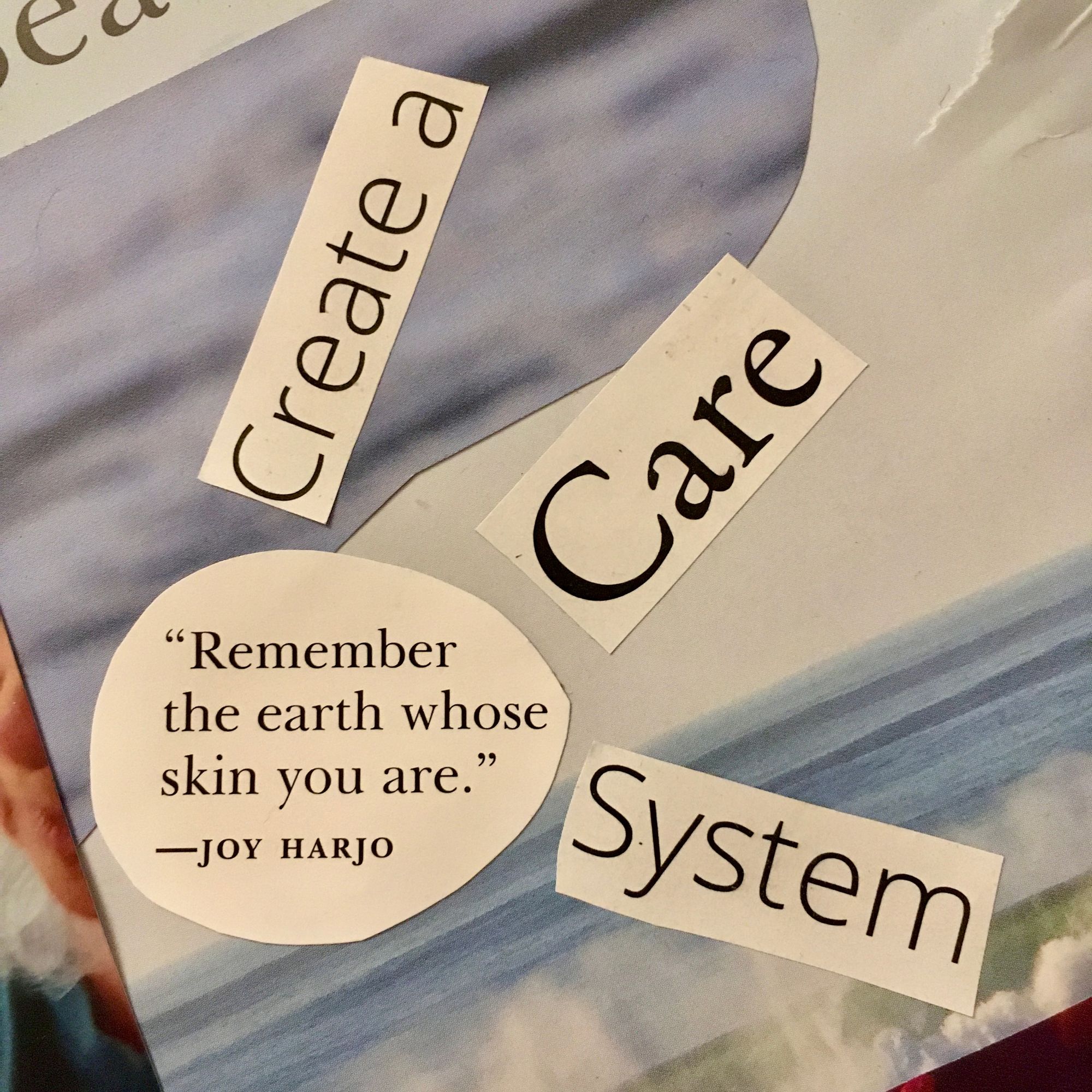 close-up of part of collage with photo of waves on bottom two layers and cut into different pieces "Create a / Care / System" oriented like sun rays out from circular cut out of quote that reads "Remember the earth whose skin you are." - Joy Harjo